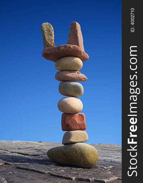 Column of balanced boulders against blue sky. Column of balanced boulders against blue sky