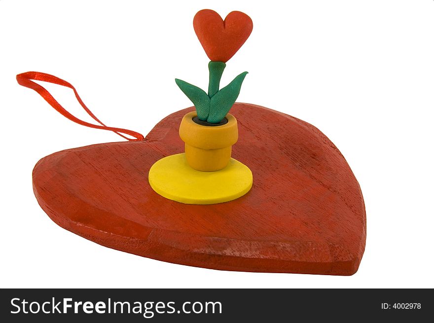 Red wooden heart with a pot of heart-shaped flower, isolated on white. Red wooden heart with a pot of heart-shaped flower, isolated on white.