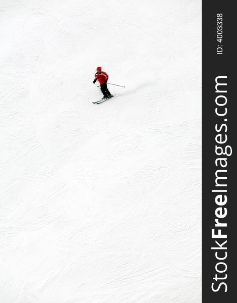 Winter scene: man moving down from the top of the mountain. The skier is motion blurred