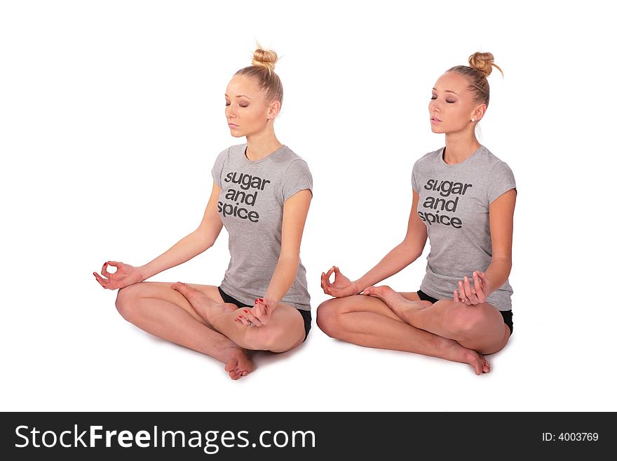 Twin sport girls meditating half-turned