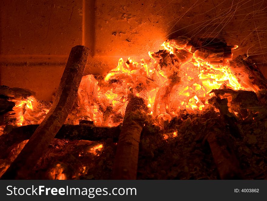 A photo of a warm fireplace with hot ashes.