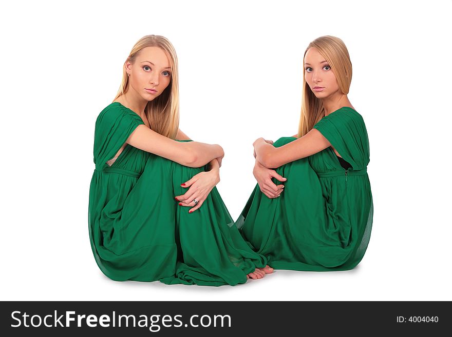 Twin girls sitting on floor on white