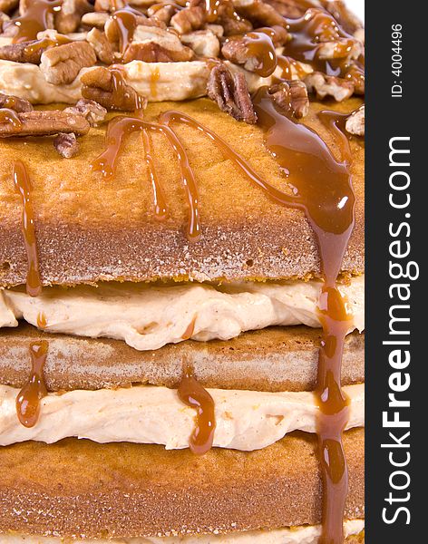 Sweet pumpkin cake dessert with cream filling and pecans on top drizzled with caramel topping on clear plate. Sweet pumpkin cake dessert with cream filling and pecans on top drizzled with caramel topping on clear plate