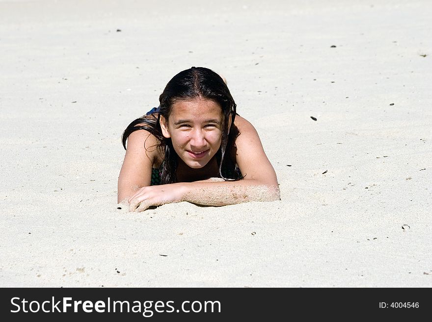 Girl lays on the sunny sand beach, warming up on hot sand after long swimming. Girl lays on the sunny sand beach, warming up on hot sand after long swimming
