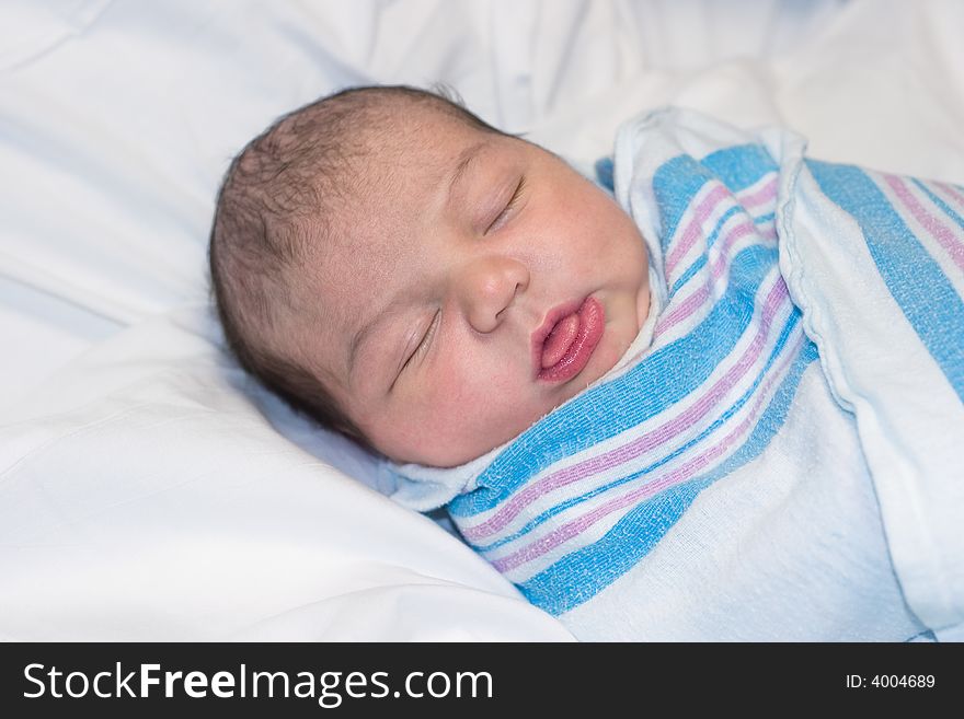 Newborn baby resting with tongue sticking out. Newborn baby resting with tongue sticking out