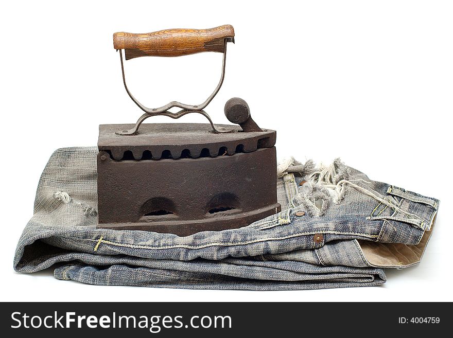 Old vintage flat-iron with jeans horizontal. Old vintage flat-iron with jeans horizontal