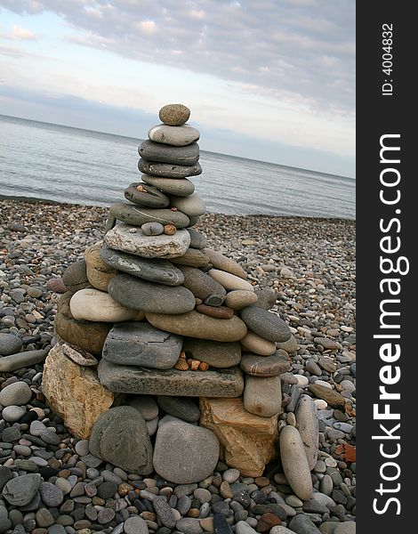 A tower made of sea rounded stones (pebbles) on the beach. A tower made of sea rounded stones (pebbles) on the beach
