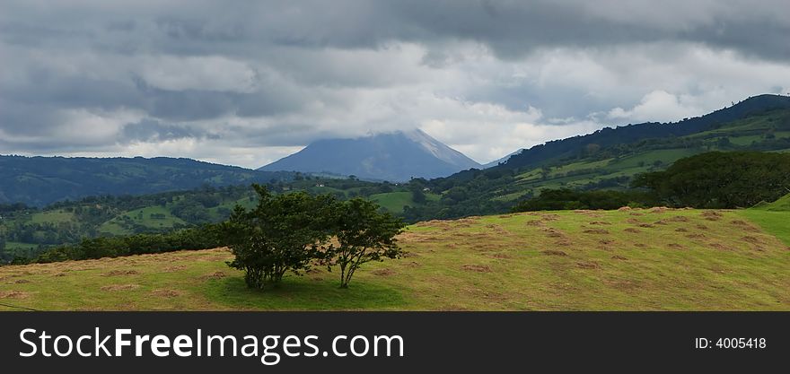 An active volcano in Costa Rica loom in the stormy background