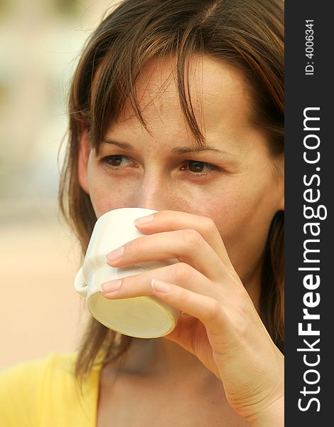 Woman drinking coffee in outdoor restaurant