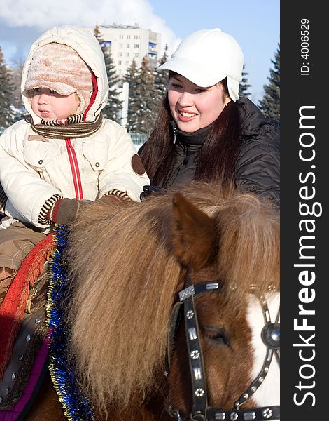 Mother and son at the horse walk, winter season. Mother and son at the horse walk, winter season