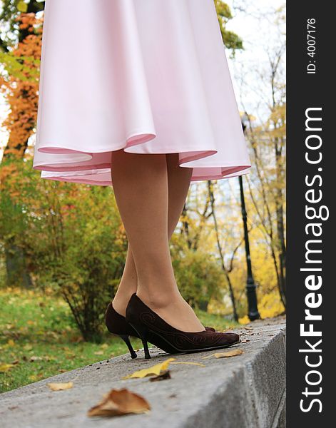 Beautiful legs in a pink skirt. Fall.