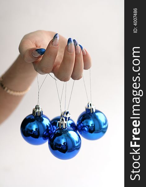 Female hand with manicure and blue balls. Female hand with manicure and blue balls