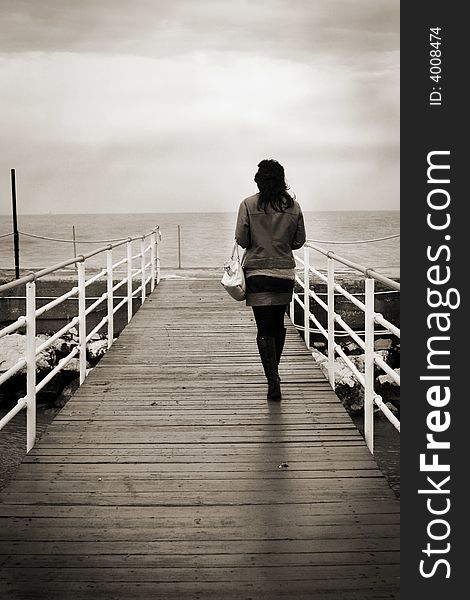 Young girl walking on a pier. Young girl walking on a pier