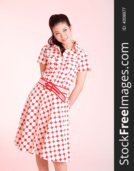 Smiling woman in red with white polka dots dress looks side way. Smiling woman in red with white polka dots dress looks side way