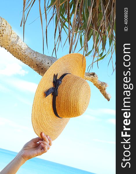 View of nice tropic scene with sailor-hat and hand. View of nice tropic scene with sailor-hat and hand