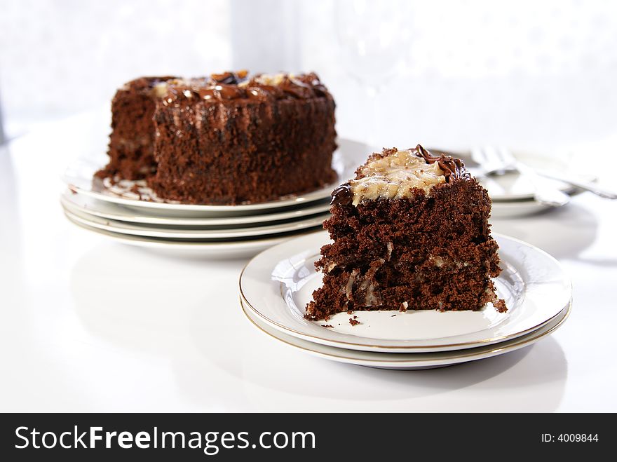 German Chocolate Cake slice with whole cake in background.