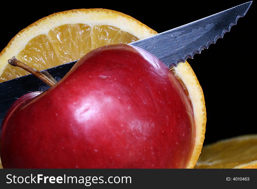 Knife and slices of fresh apple and orange.