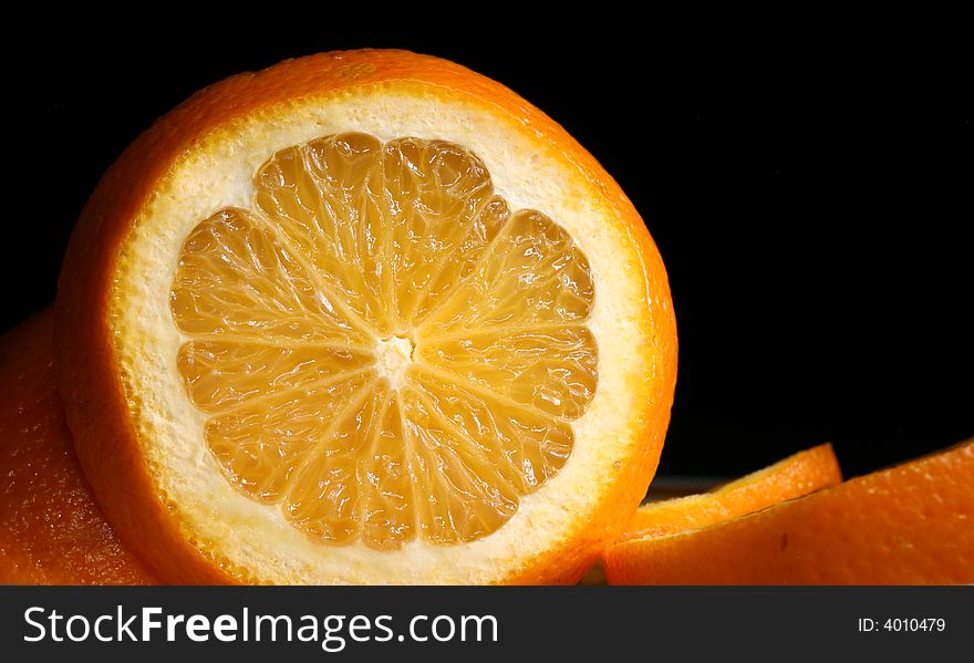 A slice of orange at the black background. A slice of orange at the black background.