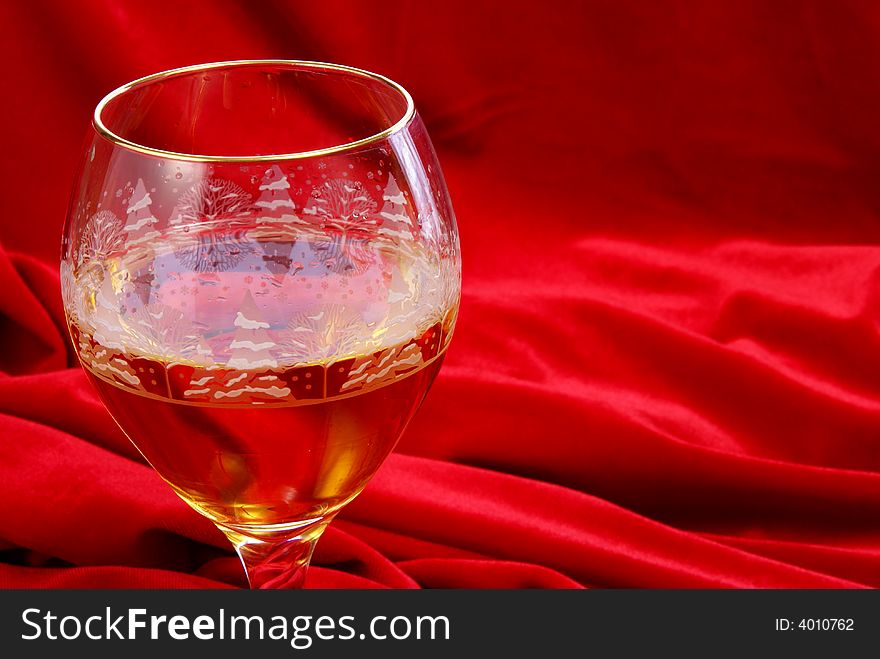 Golden wine in glass close up on red velvet. Golden wine in glass close up on red velvet