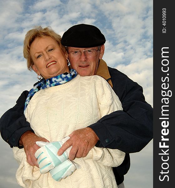 Senior man with his arms around a senior woman keeping her warm. Senior man with his arms around a senior woman keeping her warm.