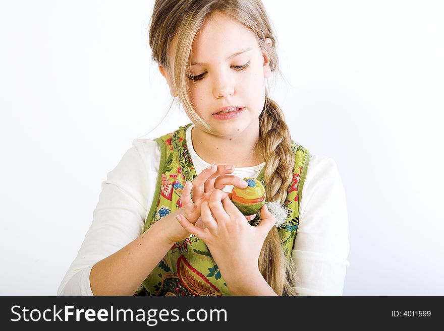 Young girl painting examening her easter egg