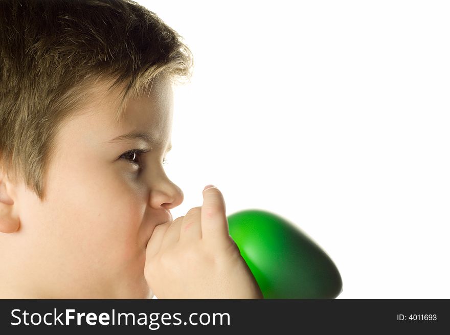 The boy inflates a green balloon on a white background
