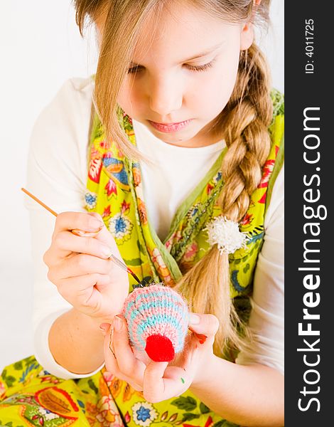 Studio portrait of a young blond girl who is painting eggs for easter. Studio portrait of a young blond girl who is painting eggs for easter
