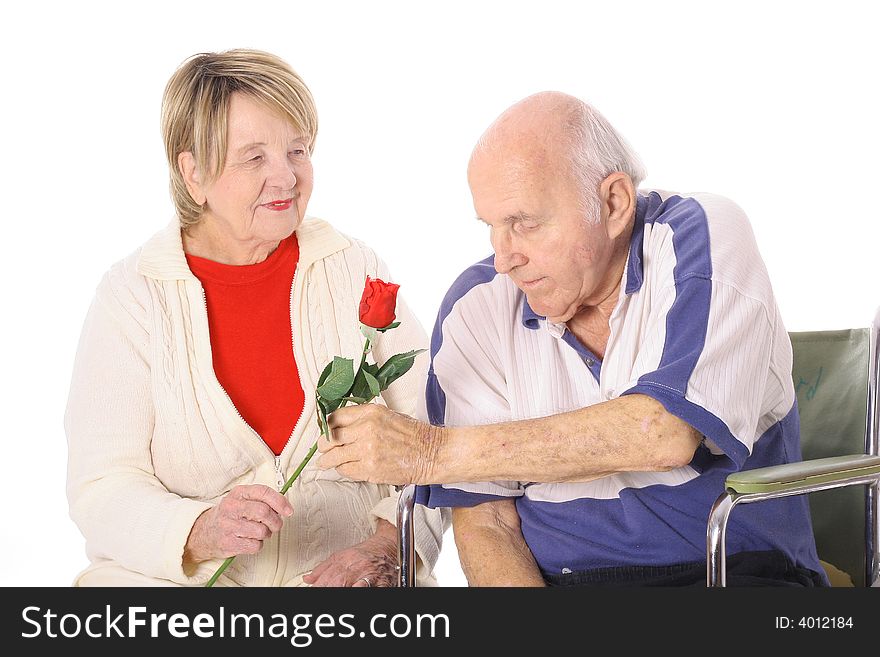 Man in wheelchair giving wife a rose isolated on white