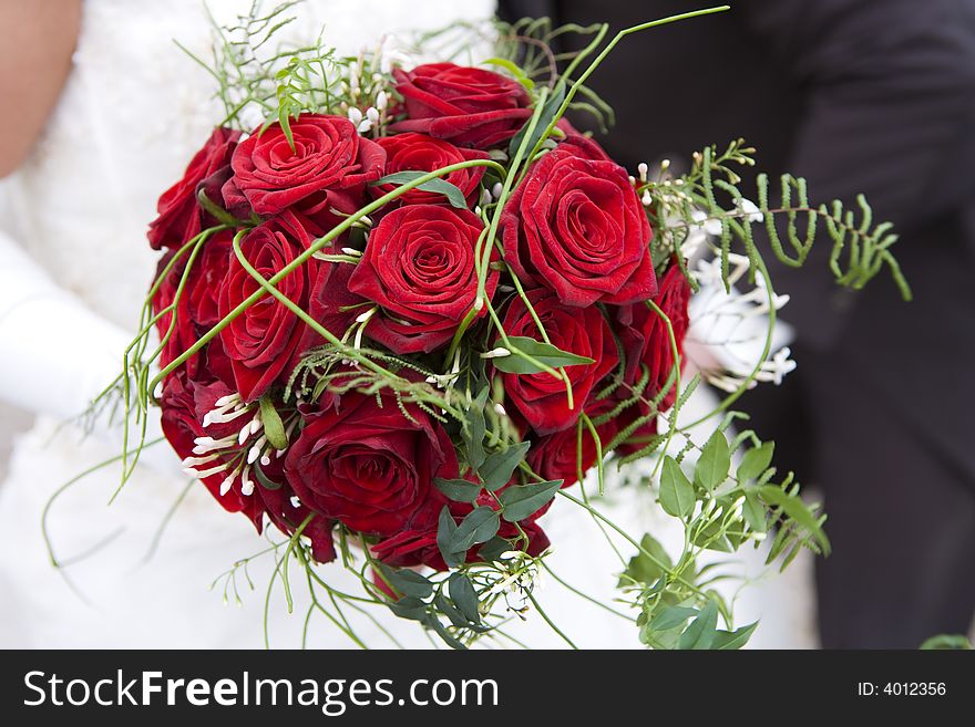 Beautifull red roses in a wedding bouquet held by the bride