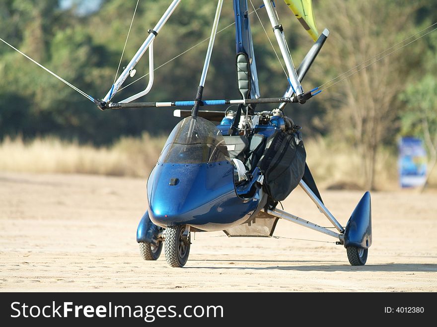 Blue microlight airplane on a dirt airfield. Blue microlight airplane on a dirt airfield