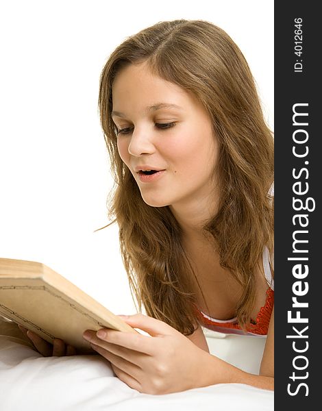 Young girl reading book in bed.