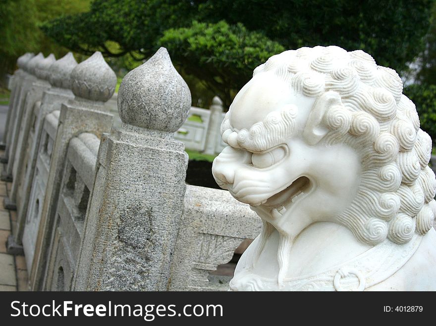 A lion guard statue in front of a japanese house