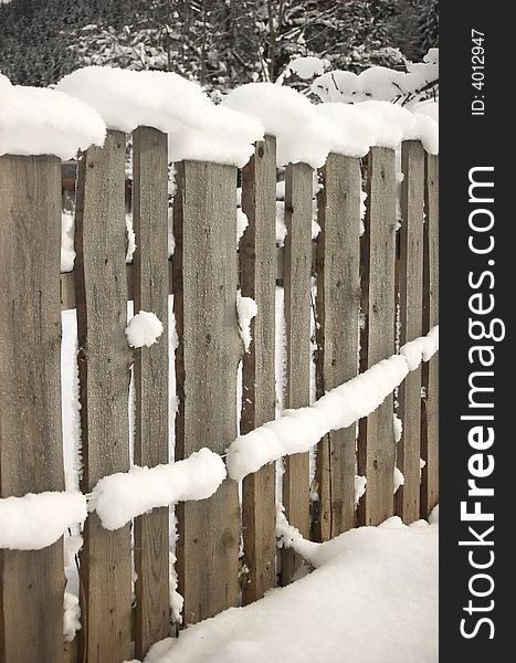 Wooden fence covered with snow, face-like shape. Wooden fence covered with snow, face-like shape