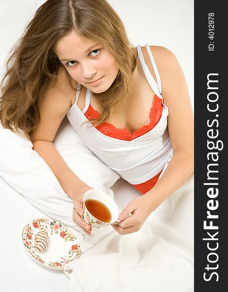 Young pretty girl drinking tea in the bed. Young pretty girl drinking tea in the bed