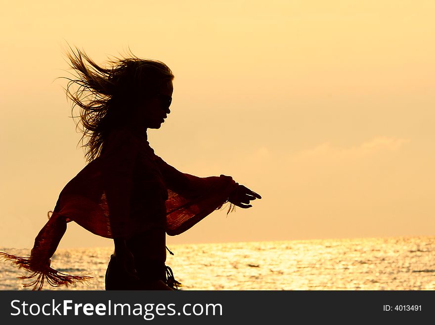 Girl silhouette on golden sunset sky background