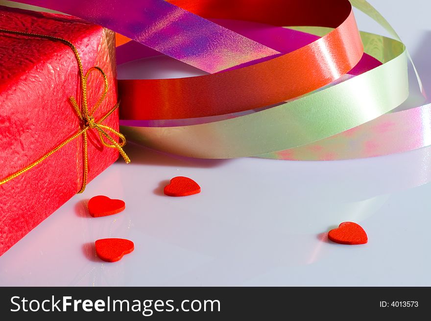 The present box, multicolored ribbon and some small hearts