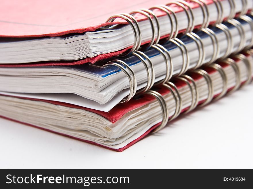 A stack of three lesson plan books with metal coil binding.