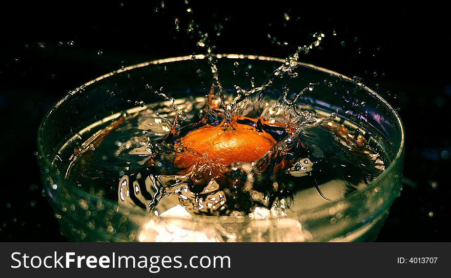 The moment while the orange fall in the water. The moment while the orange fall in the water.