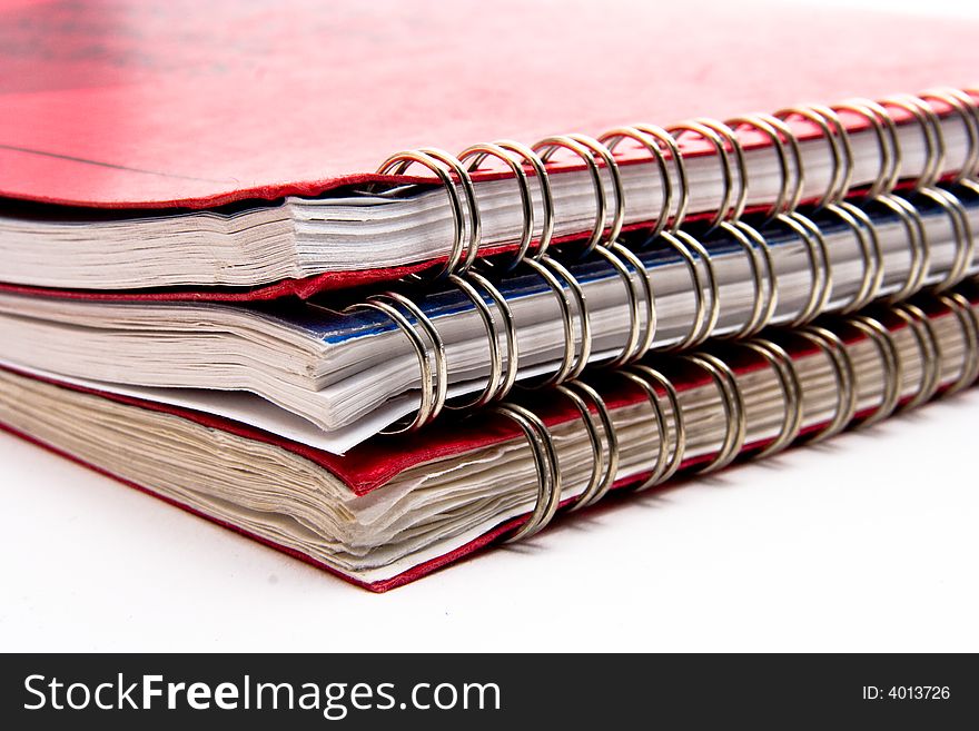 A stack of three lesson plan books with metal coil binding.