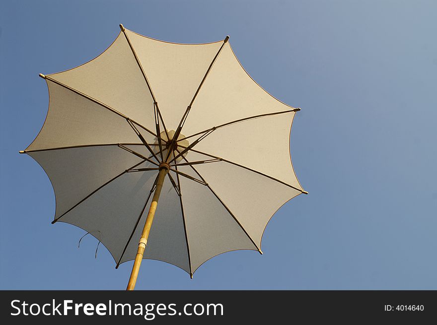 Under an umbrella and blue sky