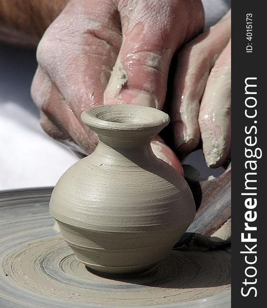 The master cuts out a pattern on a clay jug