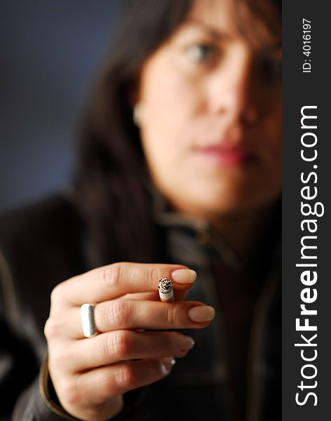 A woman holding cigarette in her hand. A woman holding cigarette in her hand
