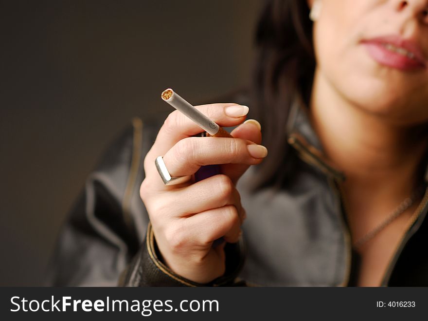 A woman with lighted cigarette in her hand. A woman with lighted cigarette in her hand