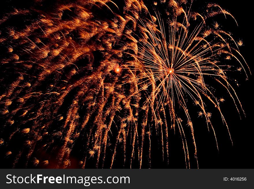 Orange  explosions with sparks on black sky. Orange  explosions with sparks on black sky