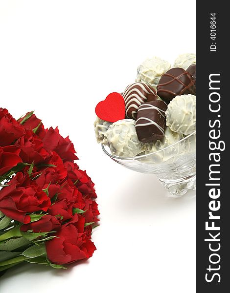 Mixed delicious chocolates with heart and a red rose on white background. Mixed delicious chocolates with heart and a red rose on white background.