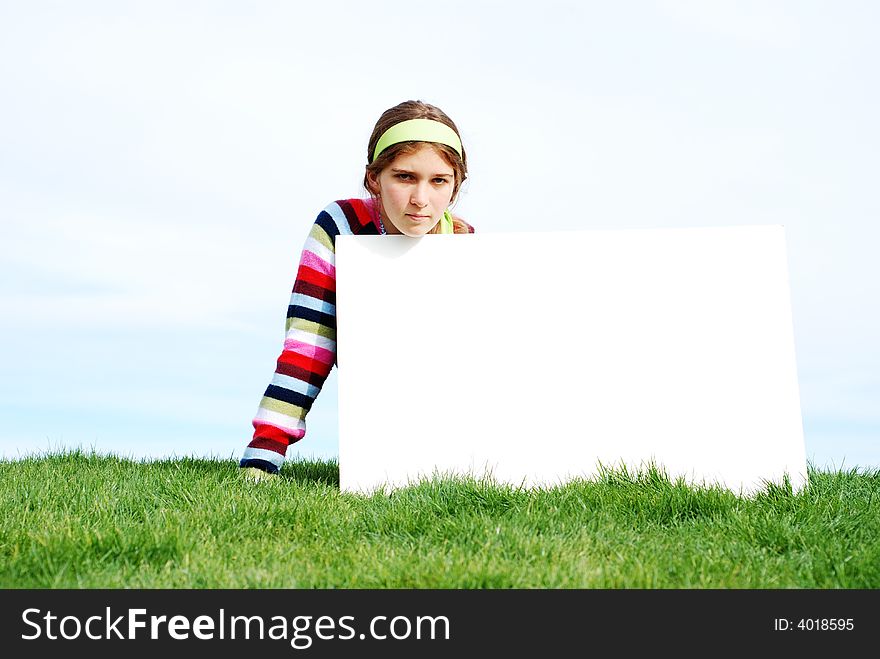 Young girl is holding a blank board at outdoor location. Young girl is holding a blank board at outdoor location