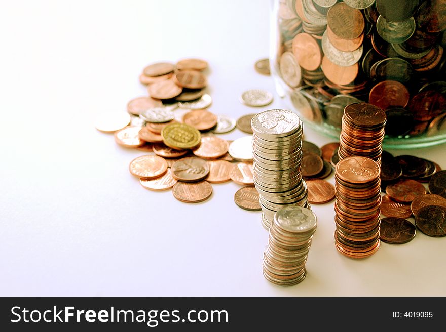 Stacks of american coins, jar of coins, white background. Stacks of american coins, jar of coins, white background