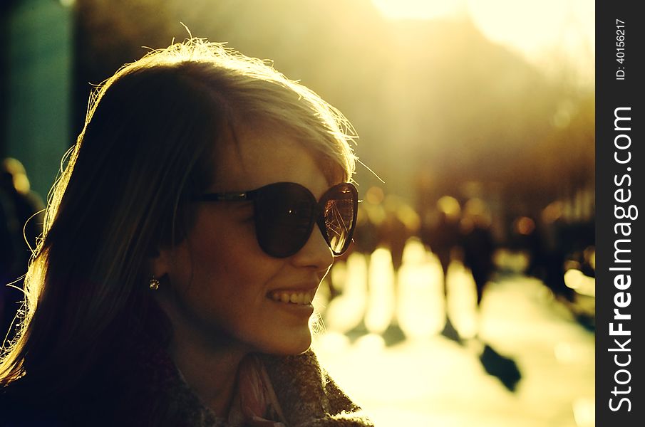 Smiling girl on the street with strong backlight