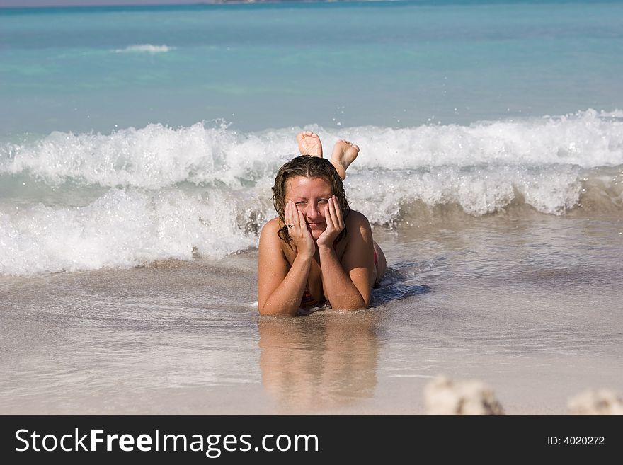 Young woman on beach bath in sea wave