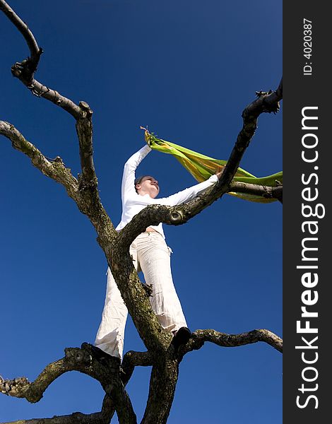 Woman with scarf on tree at blue sky. Woman with scarf on tree at blue sky